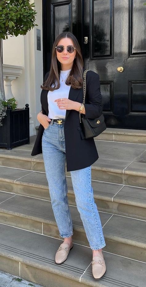A woman wearing a black oversized blazer over a classic blue jeans.