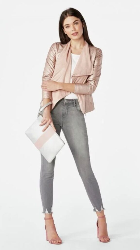 A lady wearing a dusty pink jacket and charcoal grey pants