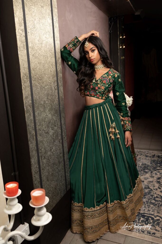 A lady dressed in a stylish Indian way in the color emerald green and gold