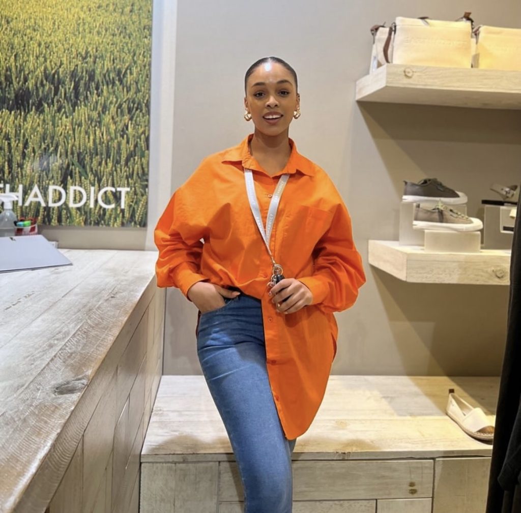 A white lady styling a long orange baggy shirt 