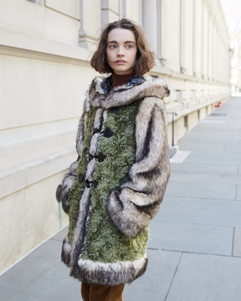 A beautiful lady wearing a sustainable faux fur jacket from a brand called Mason Atia
