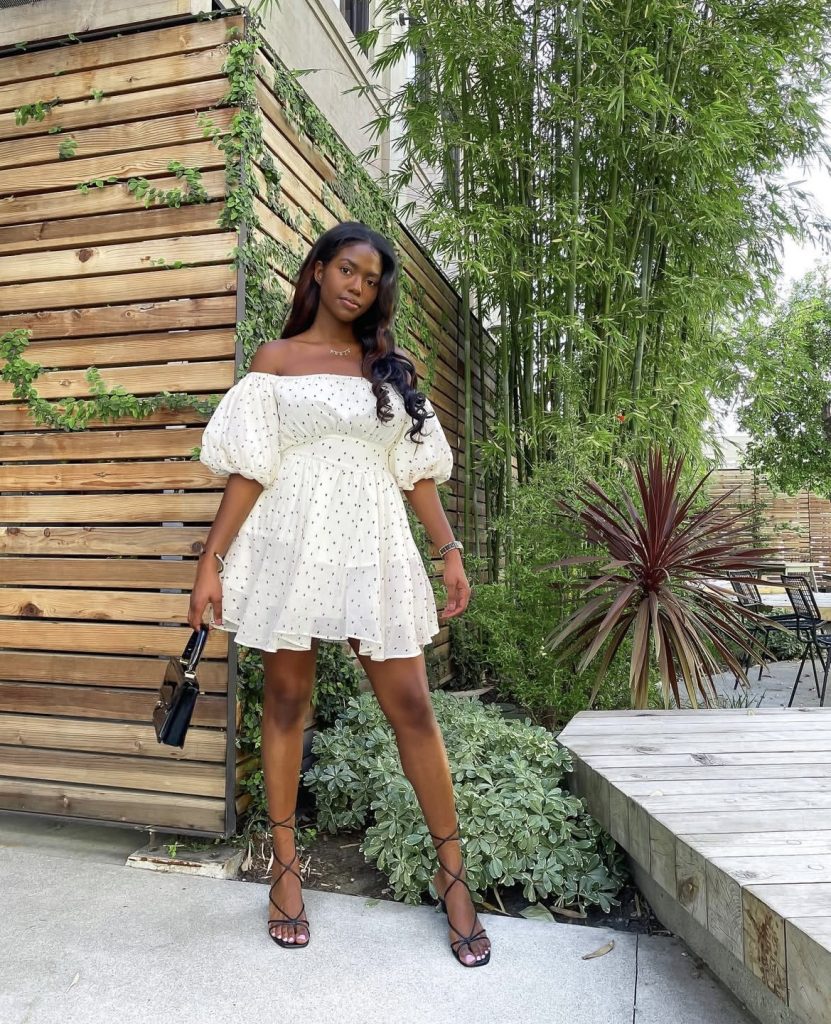 A beautiful lady wearing a puffed sleeves short white dress