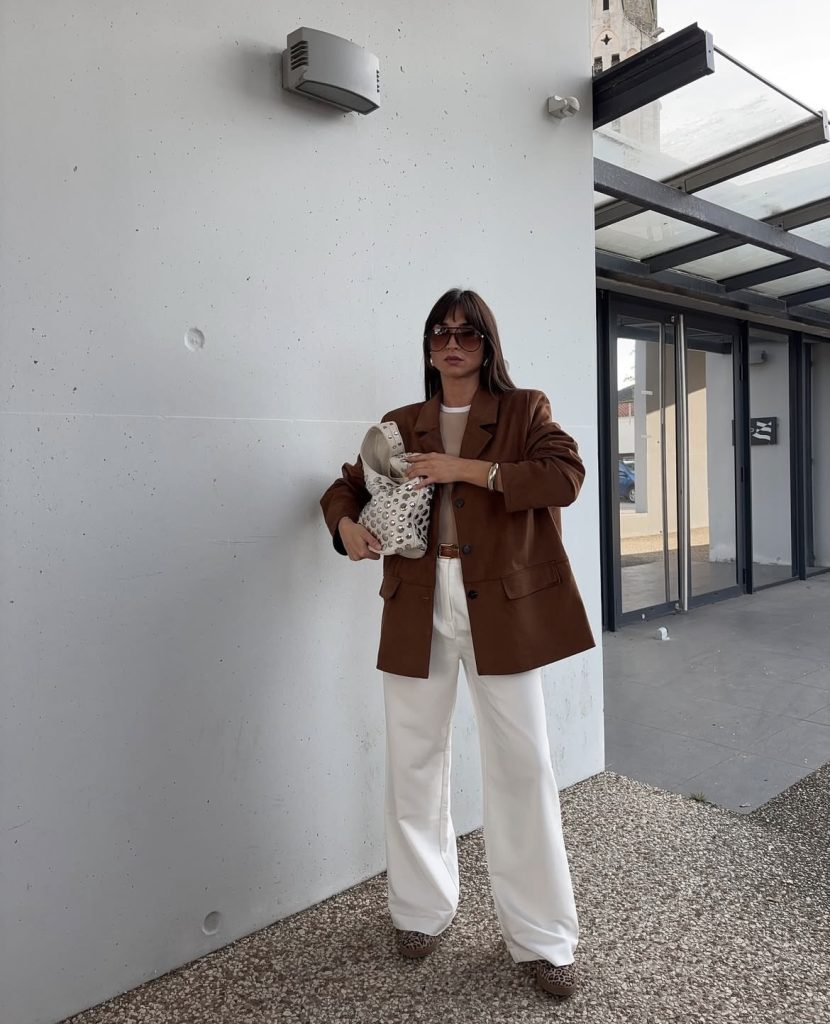 A beautiful lady wearing a white pants and brown oversized blazer