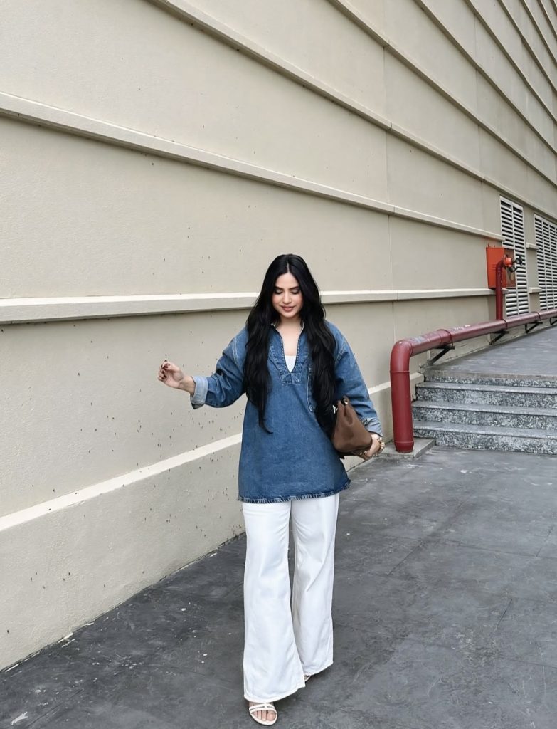 A beautiful lady wearing a white pants with a bluedenim shirt dress