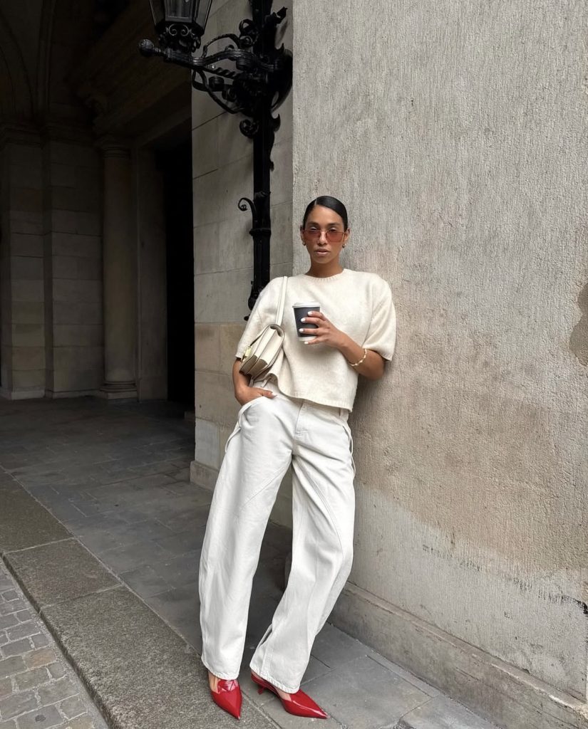 A beautiful lady wearing a white pants with sharp red covered shoe