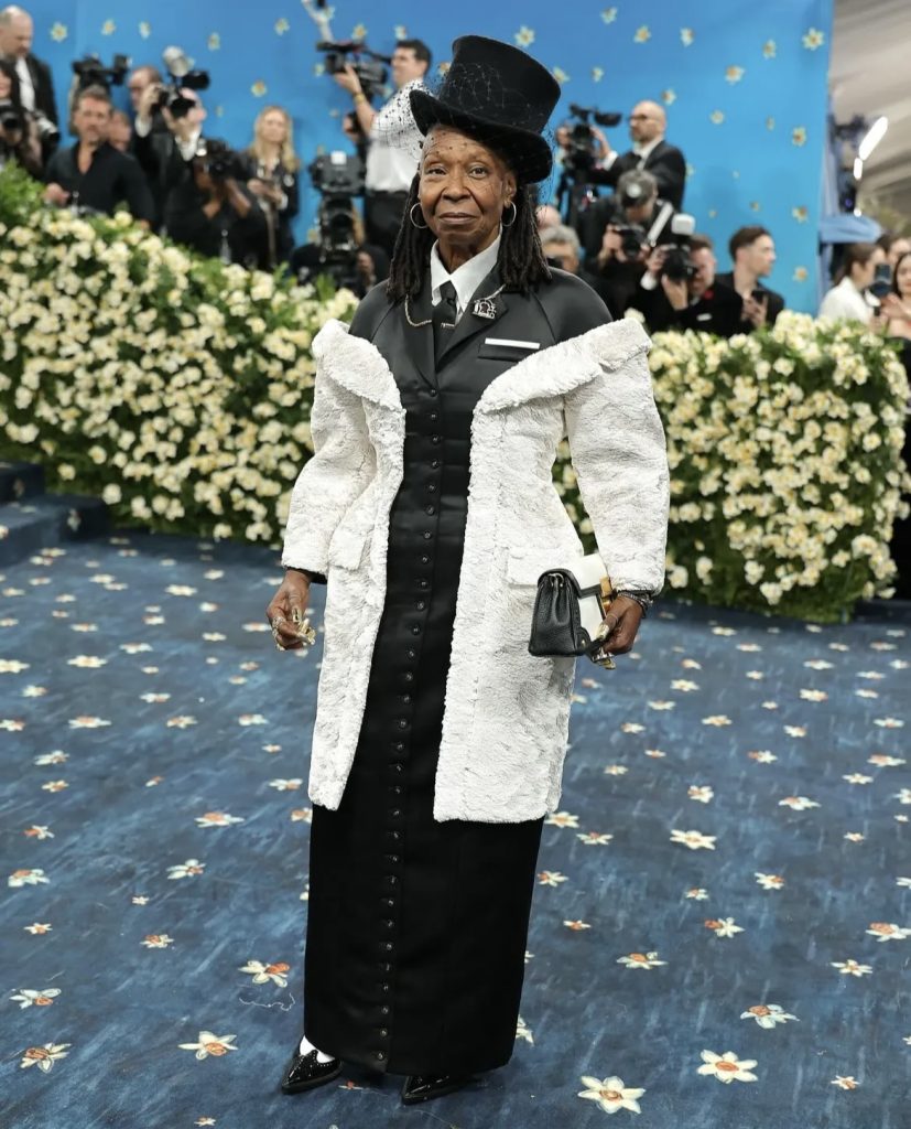 Whoopi Goldberg in a suitlike white and black dress on a red carpet