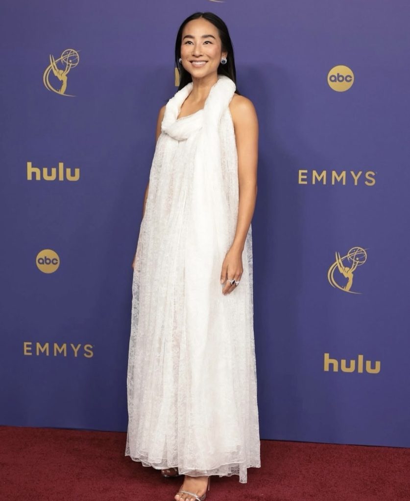 Ali Wong wearing a white dress on a red carpet