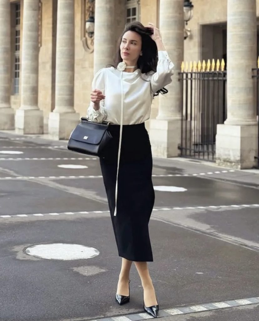 A lady wearing a white statement blouse