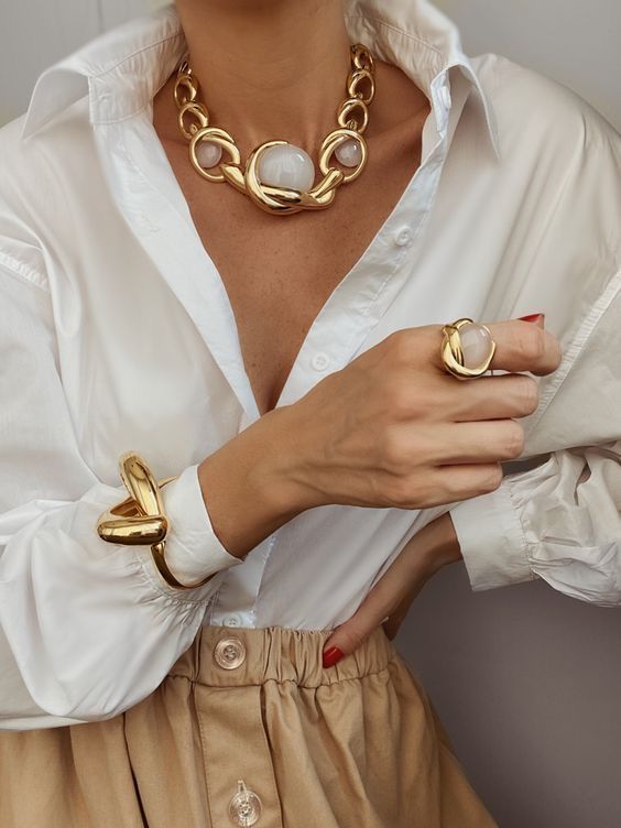 A woman wearing a white shirt with very bold jewelries