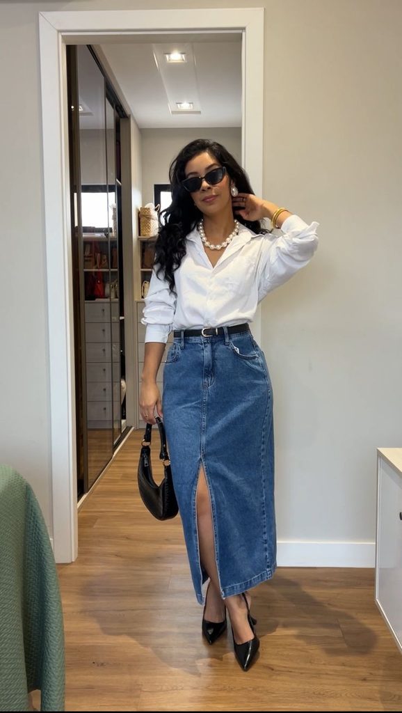 A woman wearing a white shirt withe blue denim skirt