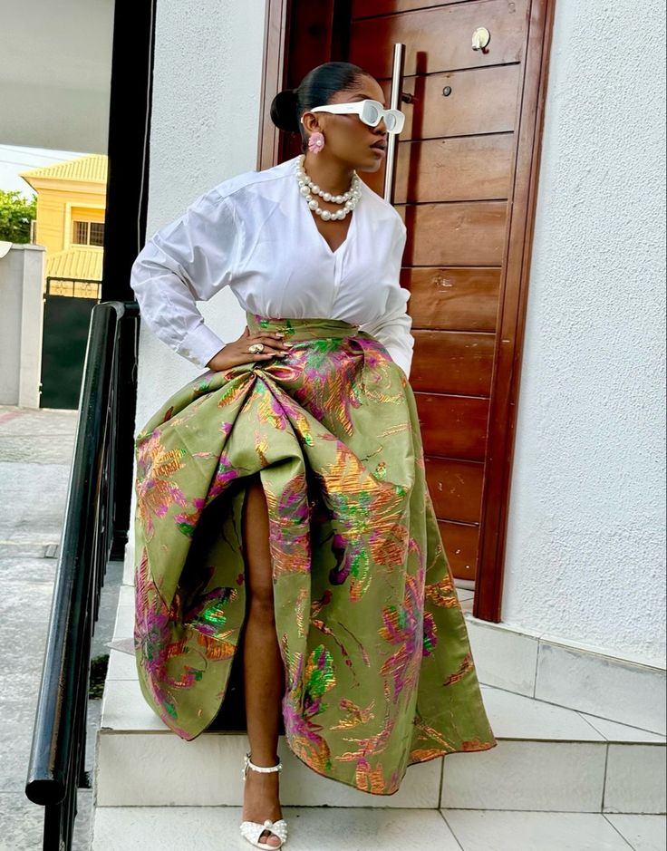 A woman wearing a white shirt with a bold olive green skirt