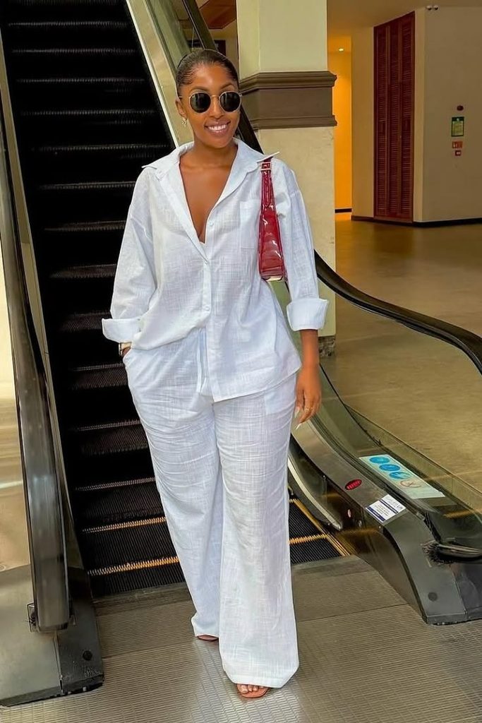 A woman wearing a white shirt and white pants two piece set