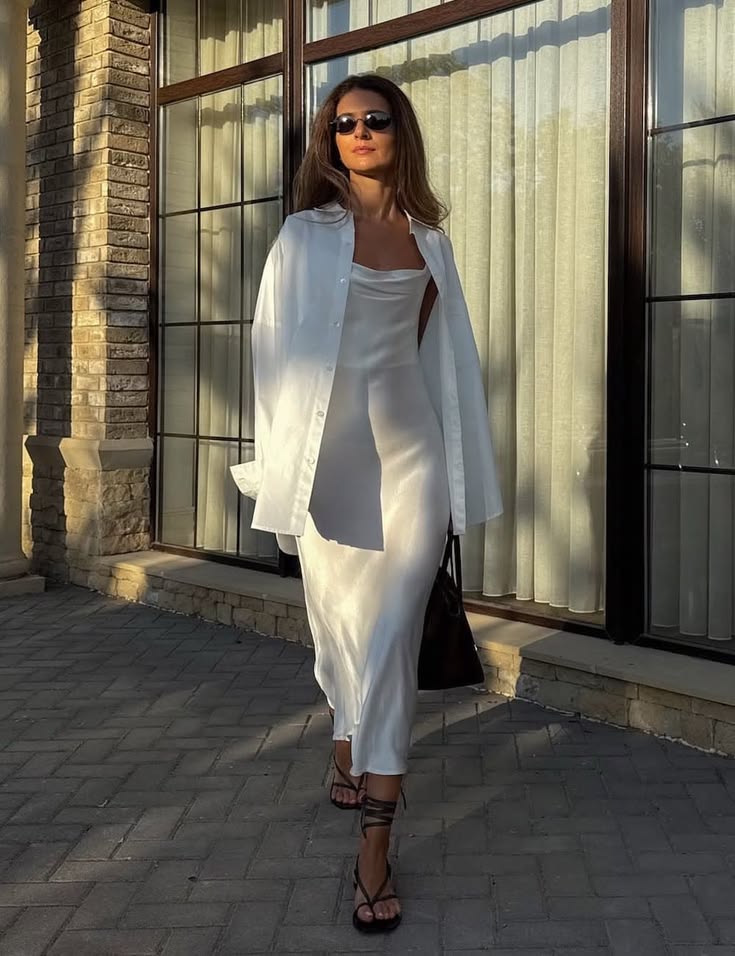 A woman wearing a white shirt with a satin dress